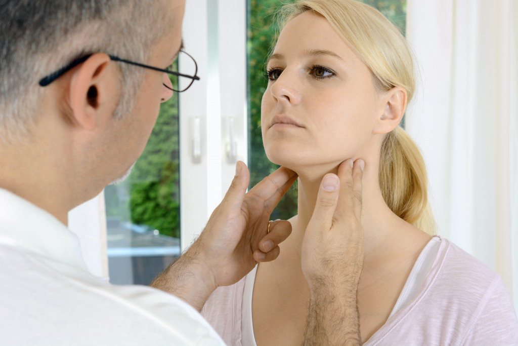 doctor touching his patients lower jaw and neck