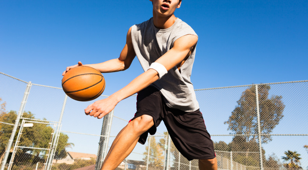 A male basketball player dribbling outside