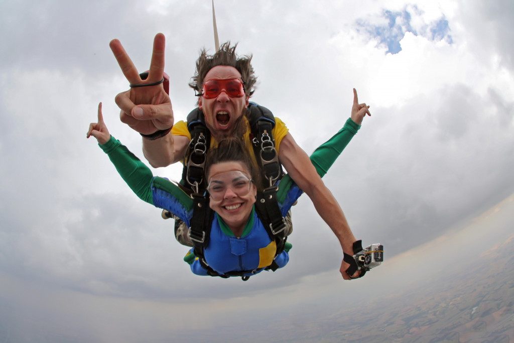 man and woman skydiving happily in tandem