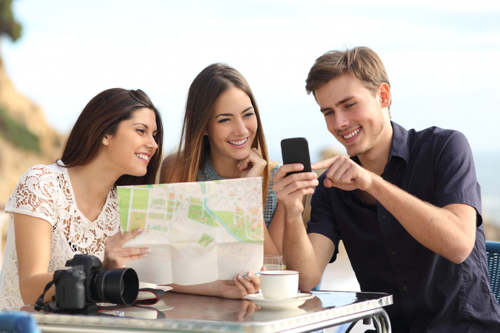 A group of friends looking at a traditional and modern map