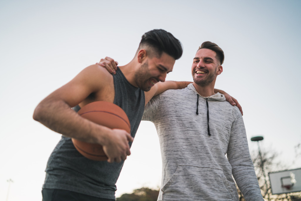 two men playing basketball laughing early morning outdoors