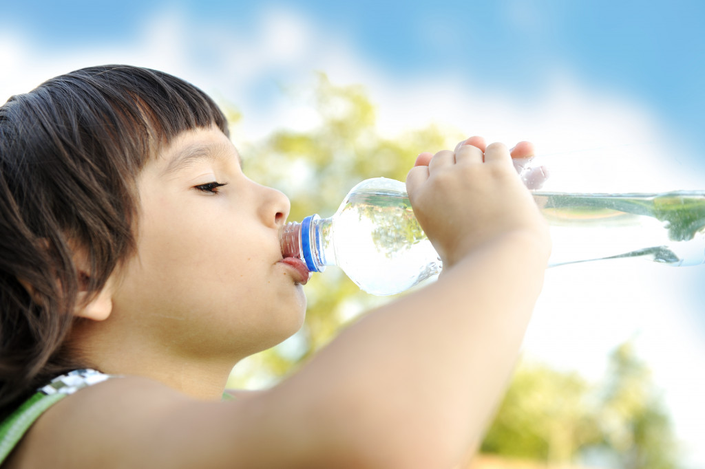 A kid drinking water from a bottle