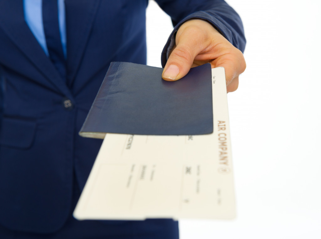 Passport and airplane ticket handed by a businessman