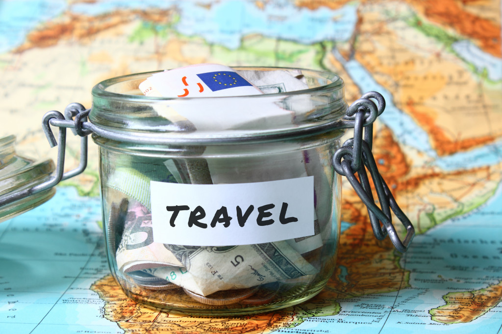 glass jar with label travel on top of world map